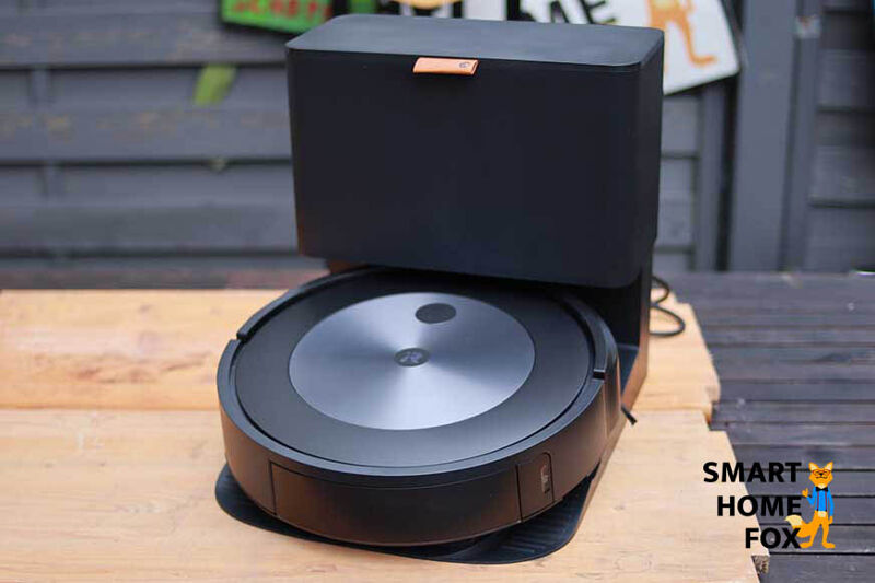 Die Absaugstation des iRobot Roomba j7+ steht samt Saugroboter auf einem Tisch